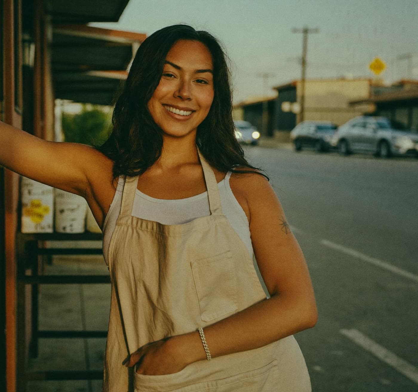 Dueña de negocio colombiana sonriendo frente a su tienda