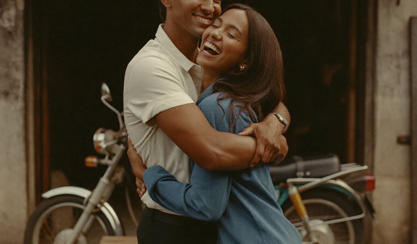 Pareja celebrando abrazada frente a su negocio